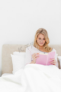 近距离拍摄，女人坐在床上看书