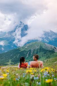 套路摄影照片_一对夫妇在意大利多洛米蒂山度假徒步旅行，欣赏塞塞达峰的壮丽景色。