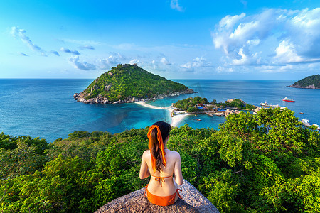 亚洲比基尼摄影照片_穿着比基尼的女人坐在泰国南园岛的观点。