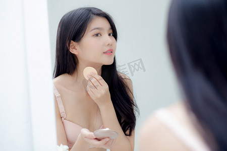 年轻亚洲女性的特写手拿着产品化妆品，在罐子里涂抹奶油，美丽的女孩手触摸乳液，以实现复兴、美丽完美、治疗和皮肤护理和健康概念。