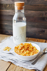 家纺背景摄影照片_碗里的美味玉米片和一瓶牛奶。