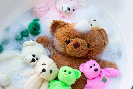 溶解摄影照片_清洗前将玩具熊浸泡在洗衣粉水中溶解。
