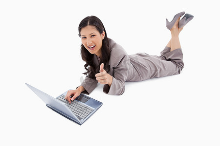 躺着的女人，带着笔记本电脑，竖起大拇指