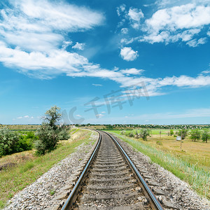 蓝色、梦幻摄影照片_绿色风景中的铁路和蓝天中的白云