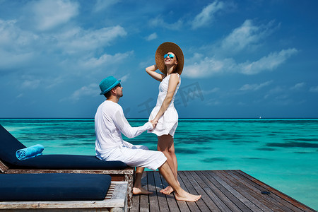 情侣白色摄影照片_马尔代夫海滩码头上的情侣