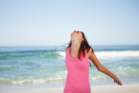海滩2024摄影照片_年轻轻松的女人站在海滩上晒日光浴