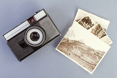 老式相机和灰色桌子上的旧照片