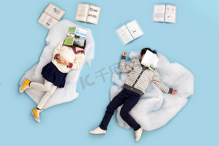 幻想图片摄影照片_快乐儿童躺在云彩上看书休息