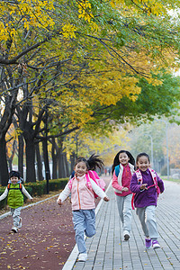 女孩跑道摄影照片_欢乐的小学生在户外奔跑