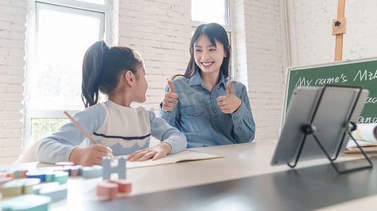 奉献摄影照片_家教老师辅导小学生学习英语