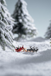 驯鹿摄影照片_雪地上驯鹿拉着圣诞老人