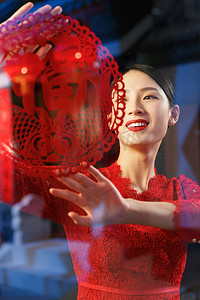中式剪纸剪纸摄影照片_年轻女人过年贴窗花