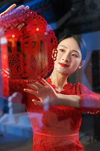 中式剪纸剪纸摄影照片_年轻女人过年贴窗花