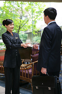 酒店名片摄影照片_商务人士和酒店服务人员在大堂交谈