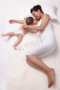 母亲和婴儿躺在床上休息