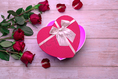 敞开心扉盒情人的礼物在木制表面，玫瑰，花瓣。情人节2月14日或浪漫的夜晚邀请函、明信片、海报、装饰品.