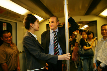 上海地铁车厢内两位中外商务人士交谈