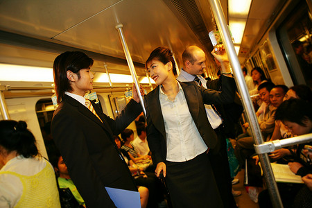 上海地铁车厢内两位商务人士交谈