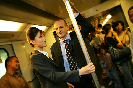 上海地铁车厢内两位中外商务人士交谈