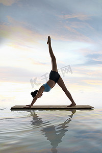 年轻女人在水面上练习瑜伽