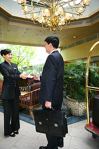 商务人士和酒店服务人员在大堂交谈