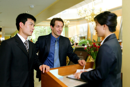 中外商务人士与酒店服务人员交谈