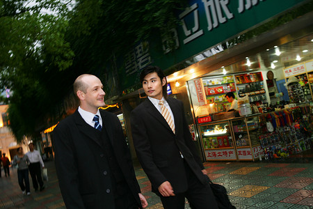 上海街头两位中外商务人士行走交谈
