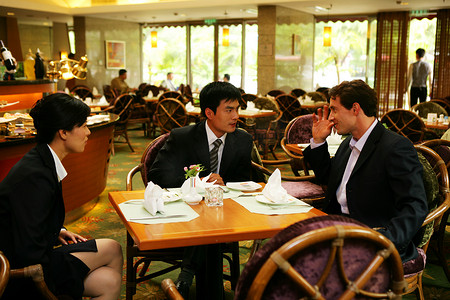 中外商务人士在酒店餐厅交谈