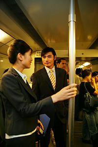 人群交谈摄影照片_上海地铁车厢内两位商务人士交谈