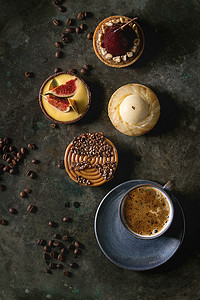 各种甜馅饼巧克力, 焦糖, 梨, 无花果与咖啡和咖啡豆周围的黑色纹理背景。平躺, 空间