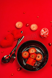 浪漫的早餐理念、红辣椒或薄薄的薄饼令甜甜的心充溢。情人节或母亲节的节日食品。草莓果酱、餐具、鲜红色背景、顶视图