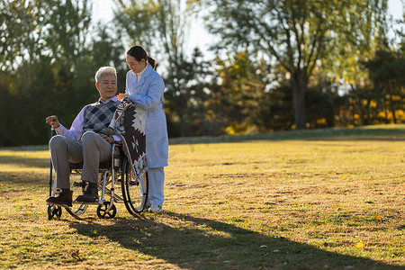 护士陪伴坐在轮椅上的老年人