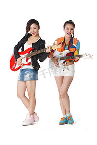 吉他手图片摄影照片_时尚活力的年轻女人弹吉他演唱