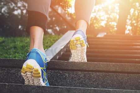 sport摄影照片_Athlete runner feet running in nature, closeup on shoe. Female athlete running on stairs. Woman fitness, running, jogging, sport, fitness, active lifestyle concept