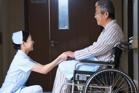 老年医生摄影照片_走廊内护士照顾坐轮椅的老人