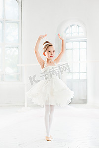 可爱芭蕾摄影照片_芭蕾舞女演员的小姑娘兔兔。在一个白色的工作室跳舞古典芭蕾的可爱孩子.