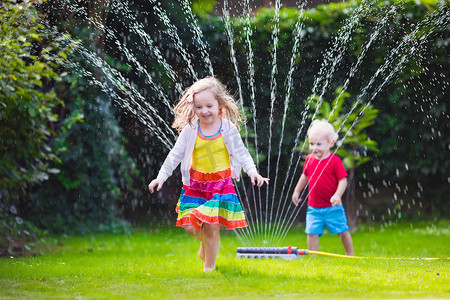 花洒摄影照片_孩子们玩花园洒水