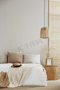 在明亮时尚的卧室的白色空墙上复制空间, 配有木制床头柜、特大号床和藤制吊灯