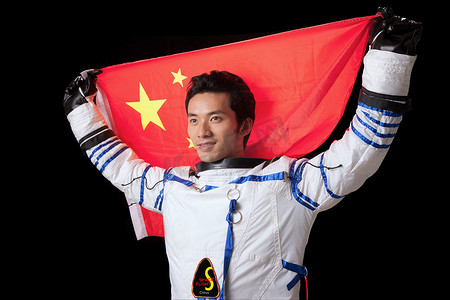 中国国旗摄影照片_一个东方宇航员手举国旗