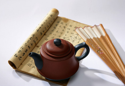 白色茶具摄影照片_茶具-茶壶,古书,扇子