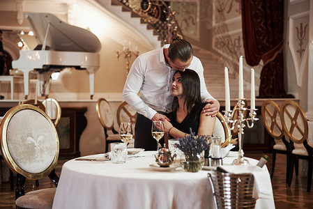 Gives kiss in the head. Beautiful couple have romantic dinner in luxury restaurant at evening time.