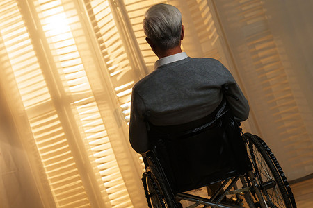 关爱空巢老人摄影照片_窗前孤独的老年人坐在轮椅上