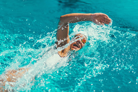 女子游泳运动员在游泳池接受训练.前爬泳风格