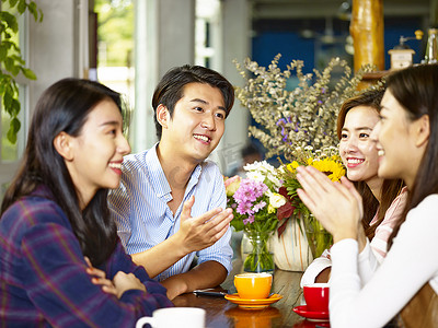 交谈的男女摄影照片_四快乐的亚洲年轻人男女在咖啡馆聊天交谈.