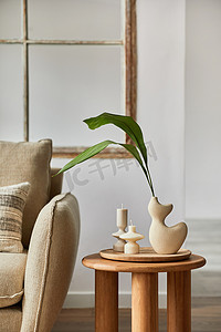 现代客厅内部细节的简约构成。木制侧桌上的创意花瓶。家居用品模板。复制空间.