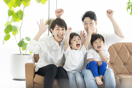 家长和两个男孩举手看电视的图片 