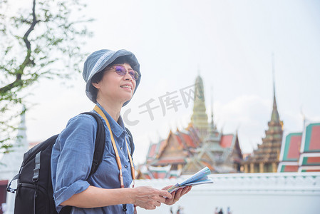 高级女游客拿着纸质地图在泰国旅游