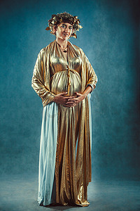 希腊女神摄影照片_金袍和花圈摆姿势孕妇喜欢希腊女神