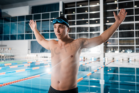 赤身裸体的运动员手拉手站在游泳池边 