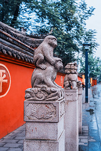 四川成都文树寺以红墙为背景的石狮雕塑。红墙上的金字翻译：和平